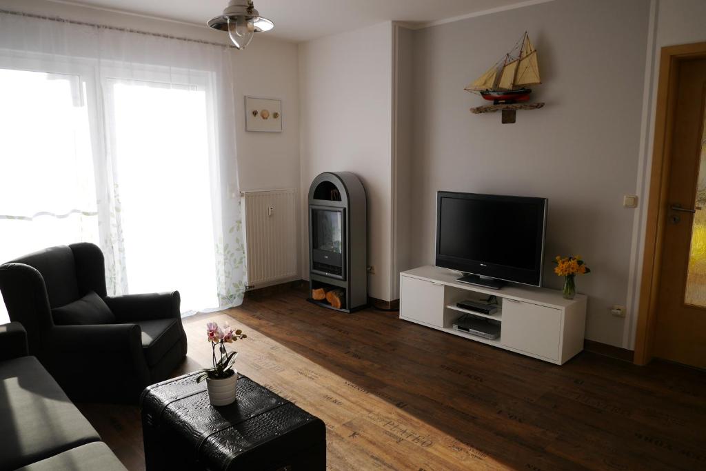 a living room with a flat screen tv on a white cabinet at Weidenhof Zinnowitz in Zinnowitz