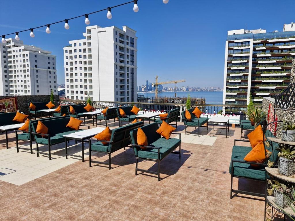 uma fila de mesas e cadeiras num pátio com edifícios em Nur Hotel Sea View em Baku