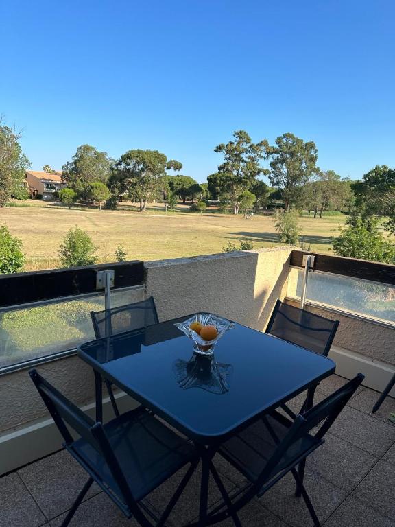 une table bleue et des chaises sur un balcon dans l'établissement Les catalanes du golf, à Saint-Cyprien