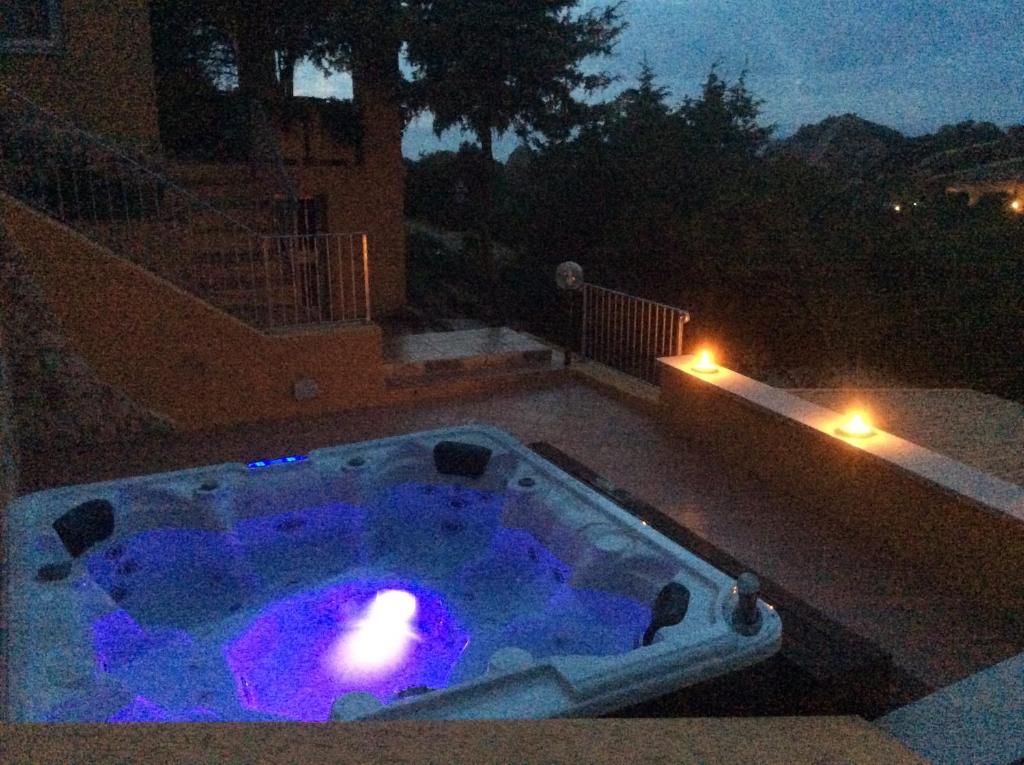 uma pequena piscina à noite com luzes roxas em Villetta Vista Mare em Costa Paradiso