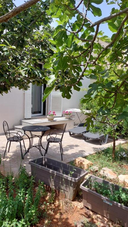 un patio con tavolo e panca in un cortile di All'ombra dell'ulivo a Monopoli