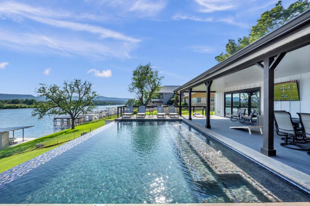 an infinity pool in a house with a view of the water at River Oaks Luxury Lakeshore Concierge Services Available in Kingsland