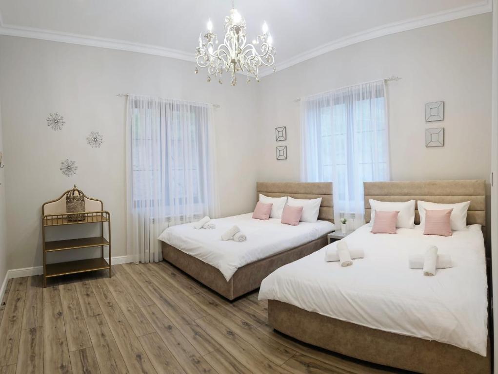 a bedroom with two beds and a chandelier at Панорамным видом на лесные горы Panorama ART in Artavaz