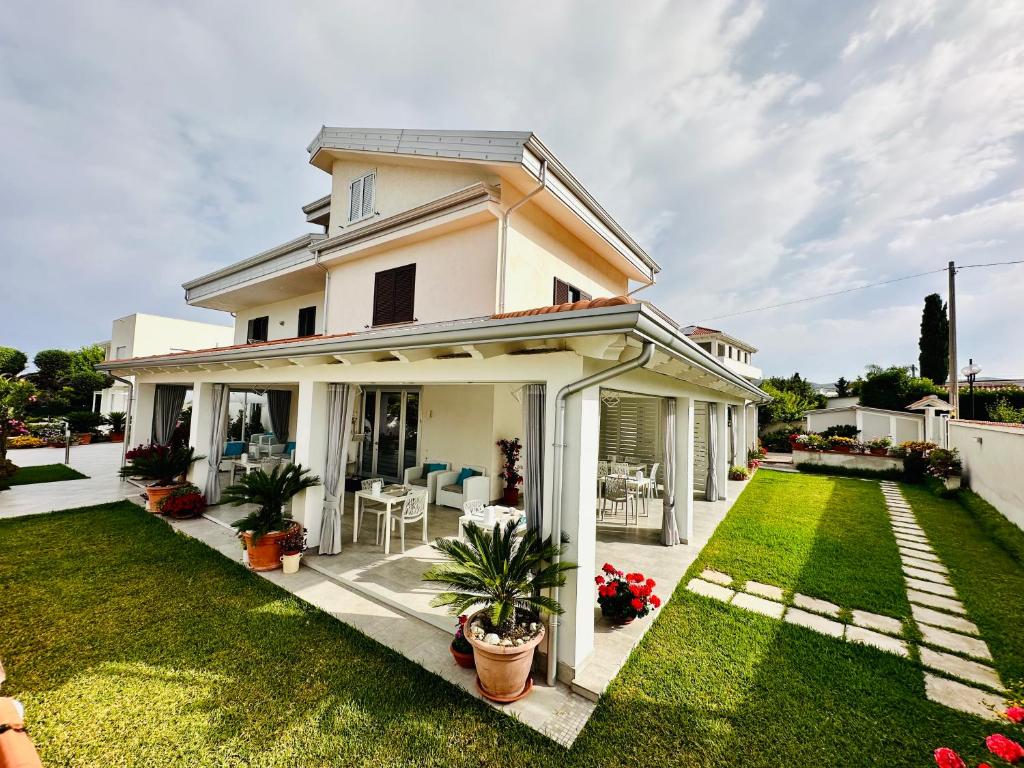 a white house with a green yard at InVilla Bed&Breakfast - Quality Rooms in Santa Maria di Castellabate