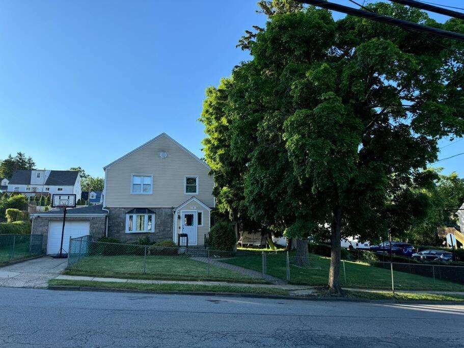 a white house with a tree on the side of a street at La Casa Bonita Near NYC in Yonkers