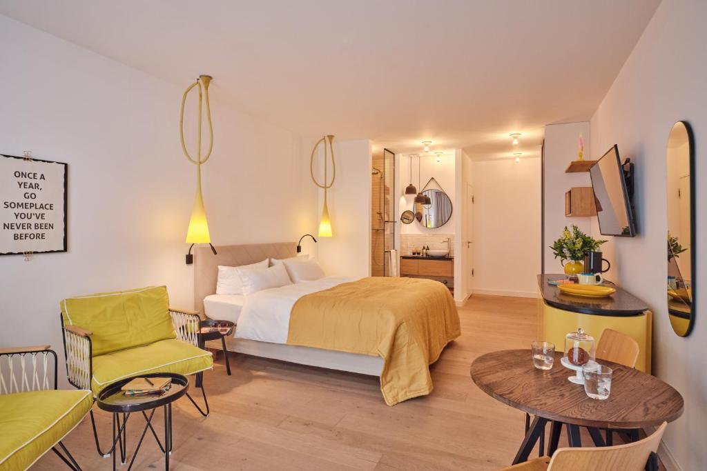 una camera d'albergo con letto, tavolo e sedie di New Wave a Norderney