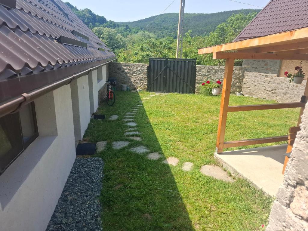 a house with a yard with a bike parked next to it at Casa nouă in Sasca Montană