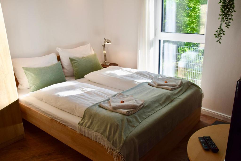uma cama com toalhas num quarto com uma janela em Stilvolle Wohnung mit Balkon & Parkplatz em Rostock