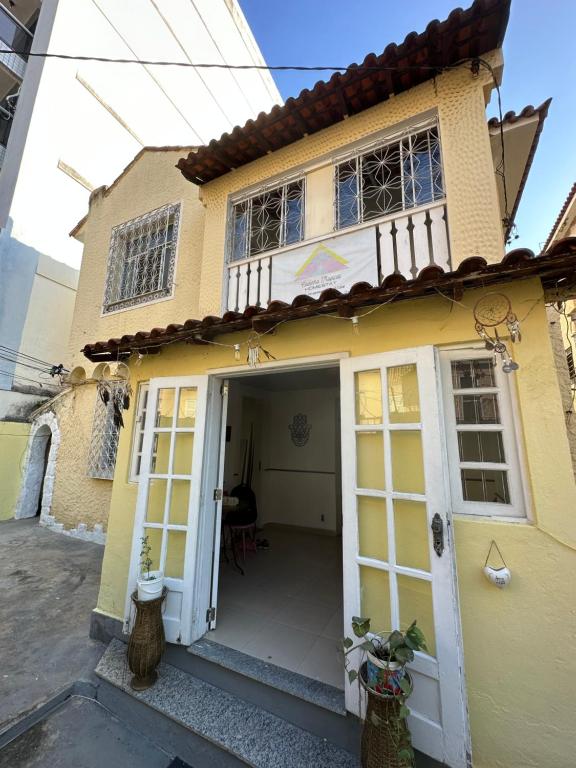 une maison jaune avec une porte blanche dans l'établissement Hostel Casinha Tropical, à Rio de Janeiro