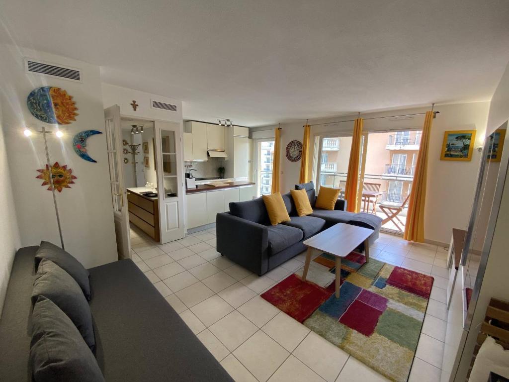 un salon avec un canapé et une table dans l'établissement Nice Magnan 2P-Piscine, Clim, Parking, à Nice