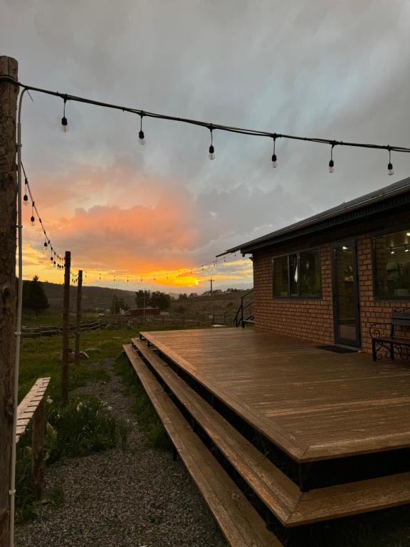 een gebouw met een houten terras met een zonsondergang op de achtergrond bij Mine Hostel Dzhergalan in Dzhergalan