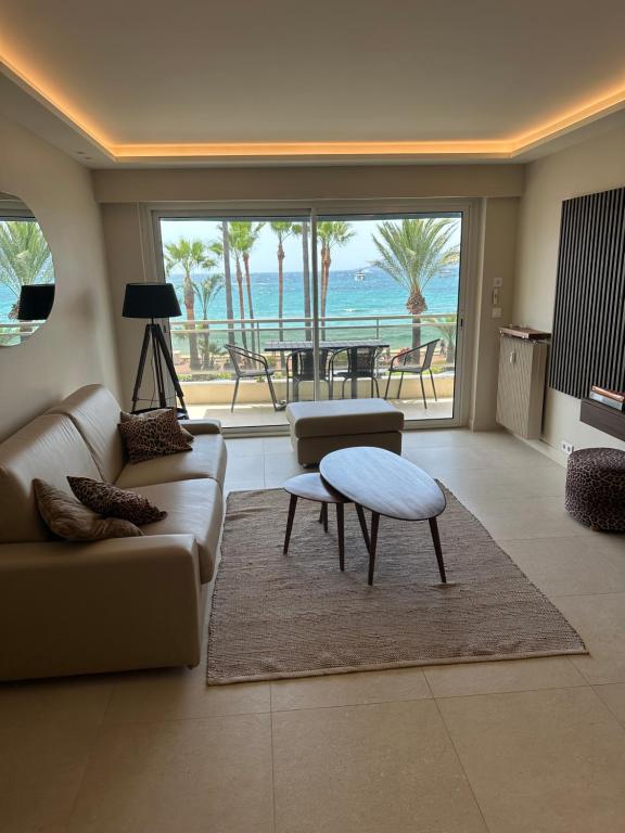 sala de estar con sofá y mesa en Appartement Rottaro luxueux 2 ch 2 sdb face à la mer, en Cannes