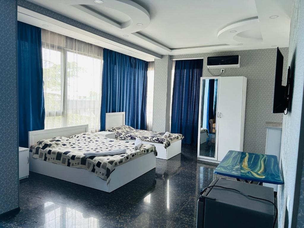 Dos camas en una habitación con cortinas azules. en Brilliant712, en Kobuleti