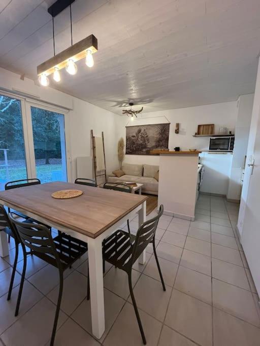 une cuisine et une salle à manger avec une table et des chaises dans l'établissement Maison à 5 mn à pied de la plage, à Soulac-sur-Mer