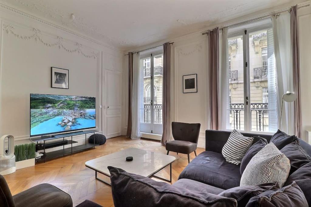 un salon avec un canapé et une télévision dans l'établissement Luxury 3 Bedrooms Apartment near Champs Elysees, à Paris