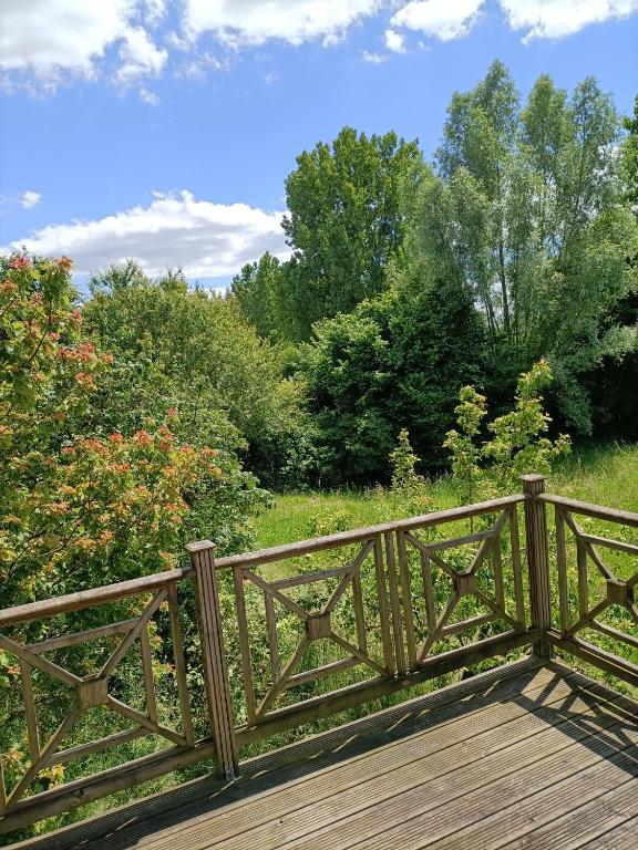 un pont en bois sur un champ arboré dans l'établissement Studio tout confort au calme, à Mayet