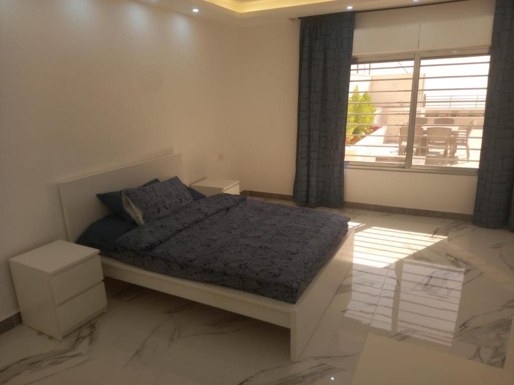 a bedroom with a bed and a large window at Ayla Chalets in Amman
