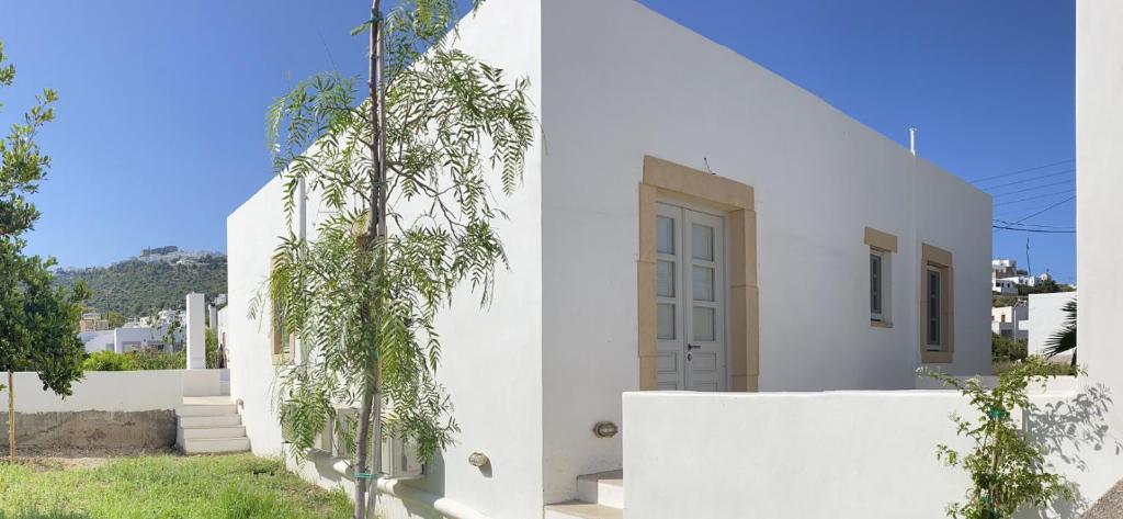a white house with a tree in front of it at Villa Palmosa in Skala