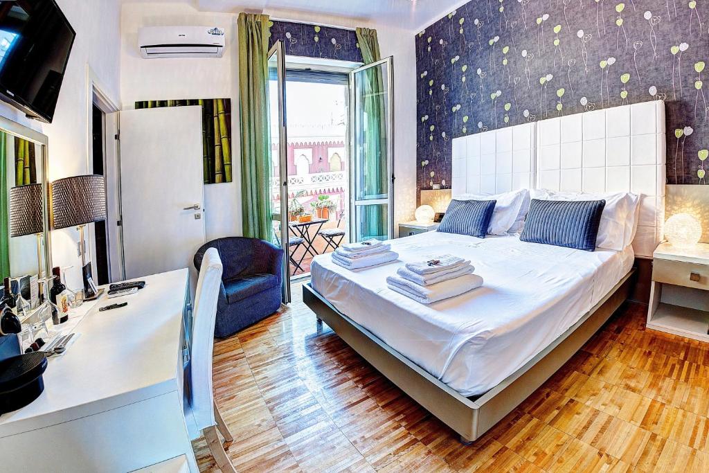 una camera con un grande letto bianco e una scrivania di Pellicano Guest House a Reggio di Calabria