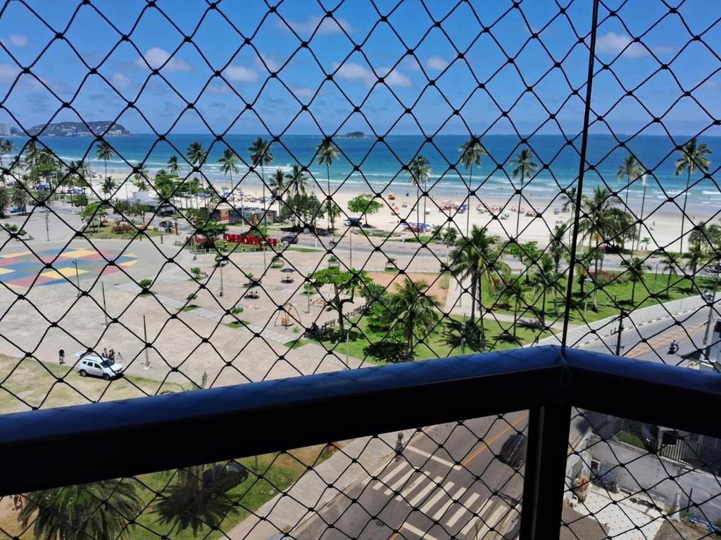 een balkon met uitzicht op het strand bij joia da enseada, com serviços de praia, de frente para o mar, 3 quartos, TV smart, piscina, academia, salão jogos, brinquedoteca, estacionamento in Guarujá