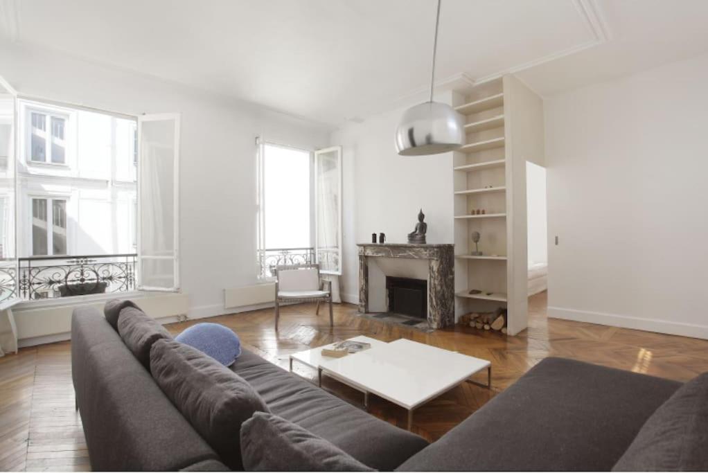 un salon avec un canapé et une cheminée dans l'établissement appartment d'architecte, à Paris