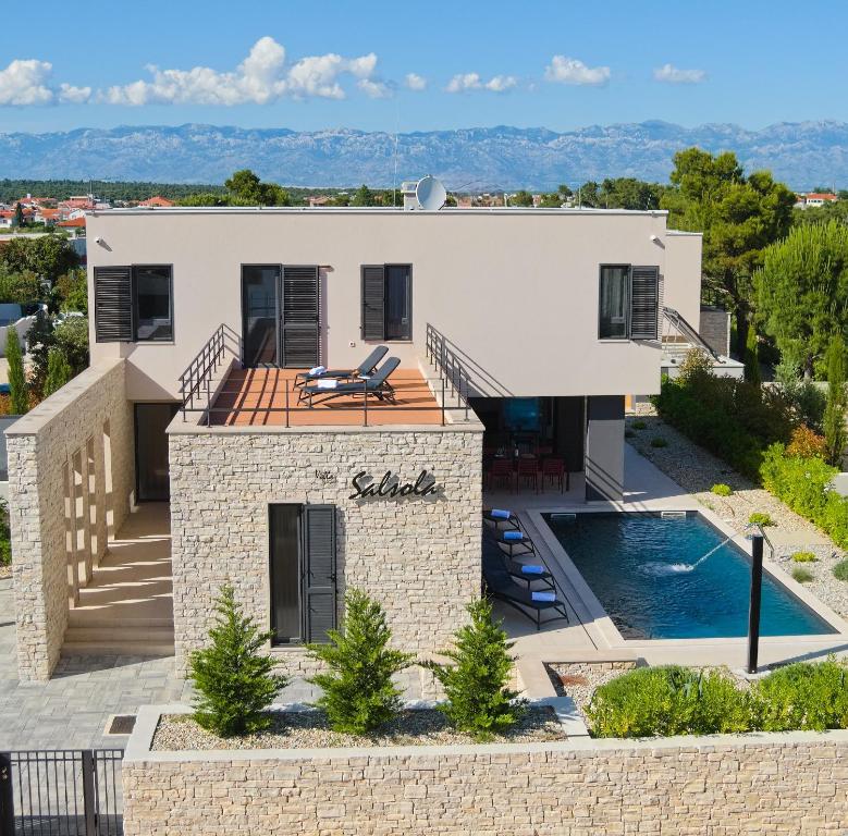eine Villa mit Swimmingpool und ein Haus in der Unterkunft Villa Salsola in Zaton