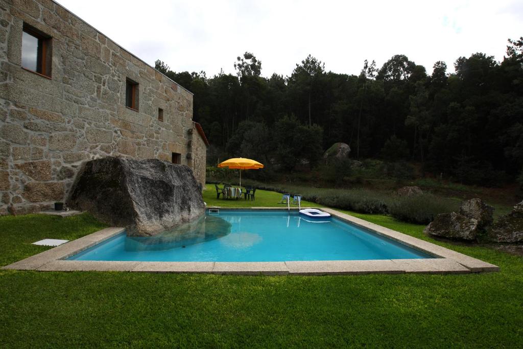 una piscina en un patio junto a un edificio en Quinta de Pindela - Natureza e Tradicao, en Vila Nova de Famalicão