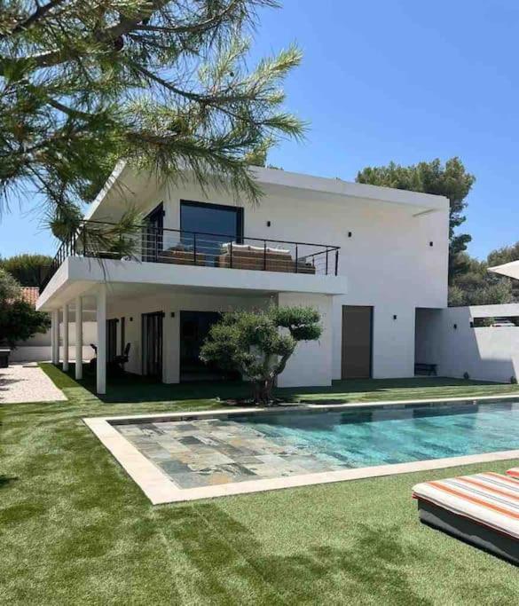 une grande maison blanche avec une piscine devant dans l'établissement Calanques Park Villa, à Cassis