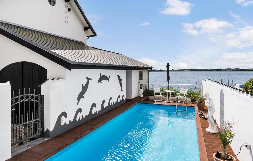 una piscina con delfines pintados en el lateral de un edificio en Nice Home In Hejls With Sauna, en Hejls