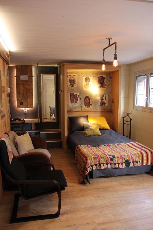 une chambre avec un lit et une chaise dedans dans l'établissement Chaleureux meublé Chessy Proche Disney, à Chessy