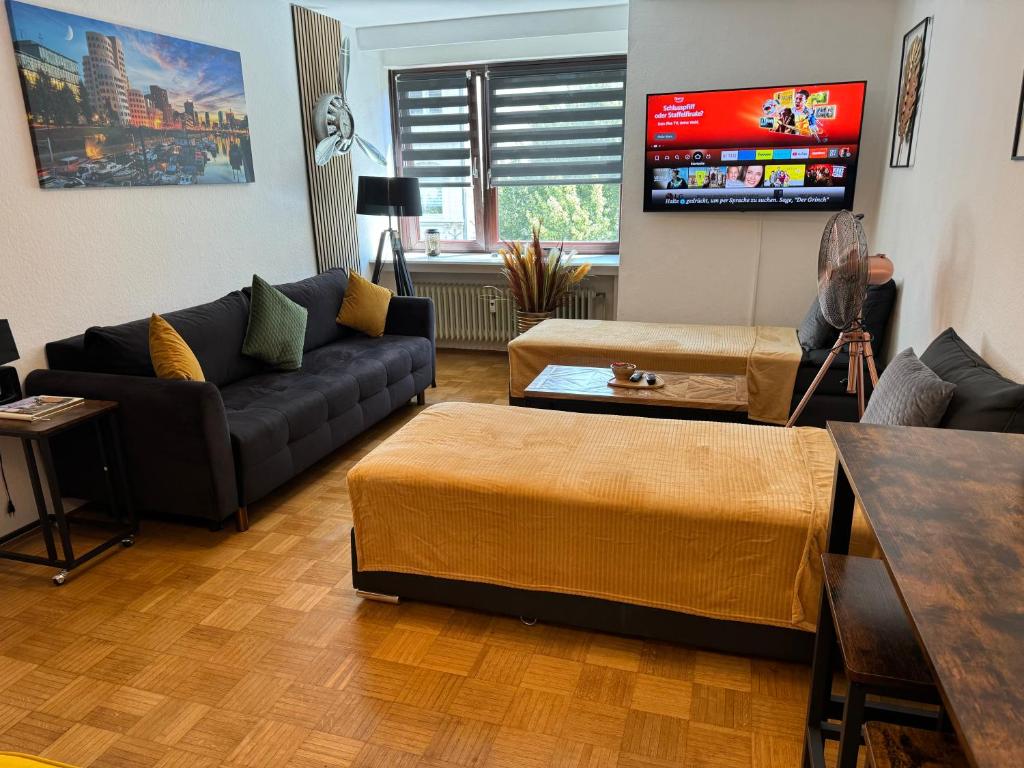 a living room with a couch and a tv at Offline 51 City Apartments in Düsseldorf