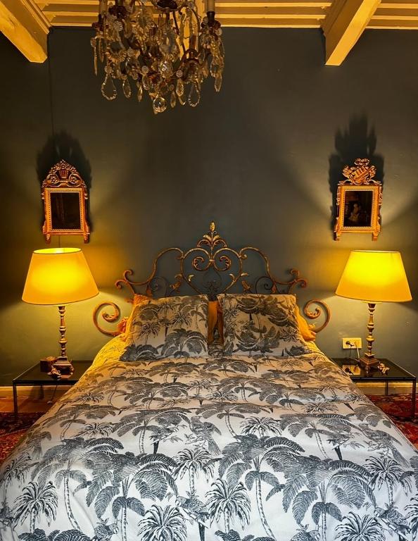 - une chambre avec un lit, deux lampes et un lustre dans l'établissement manoir de Rivières, à Rivières