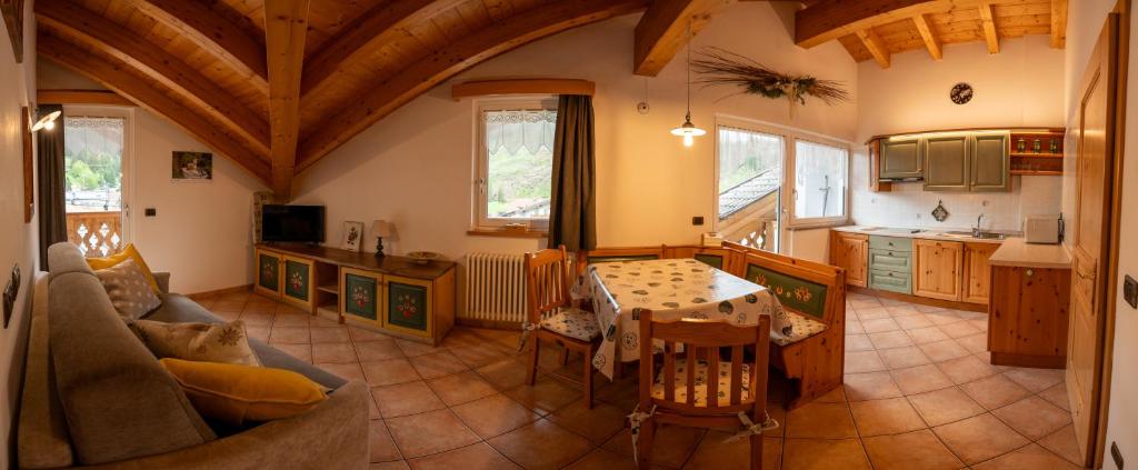 a living room with a table and a kitchen at Cèsa Castlunger in Canazei