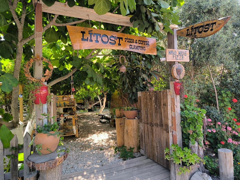 an outdoor garden with a bunch of plants and signs at Litost Cafe in Adrasan