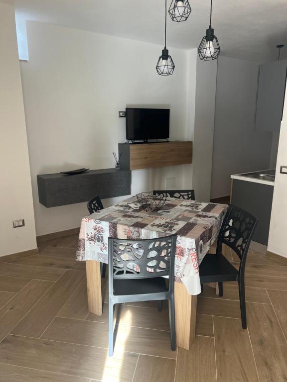 a dining room table with two chairs and a kitchen at Casa Marisol in San Giovanni Suèrgiu