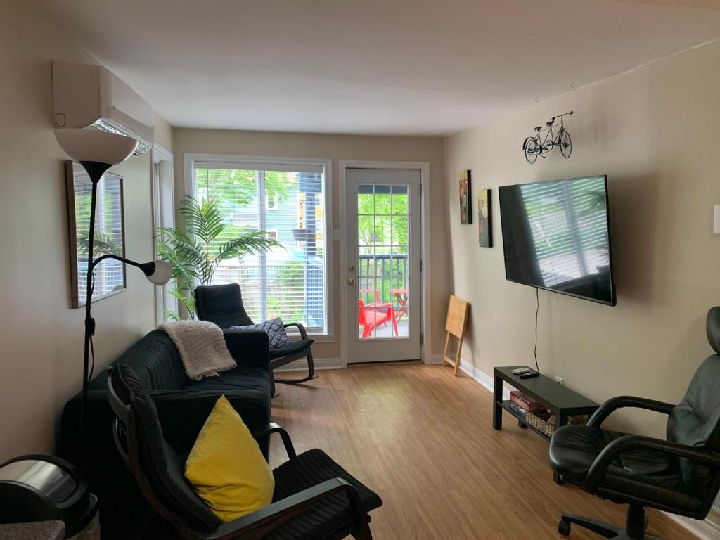 a living room with a couch and chairs and a television at Two bedrooms and large office close to Halifax Citadel in Halifax