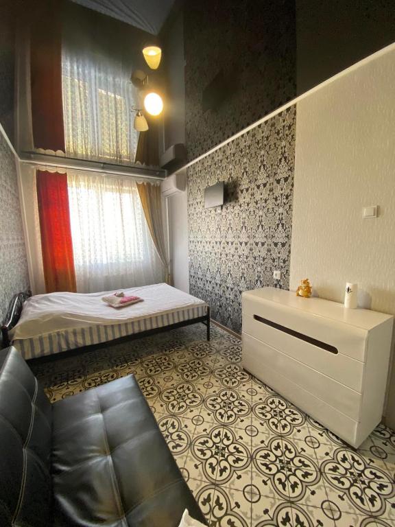 a small bedroom with a bed and a window at Морской бриз in Odesa