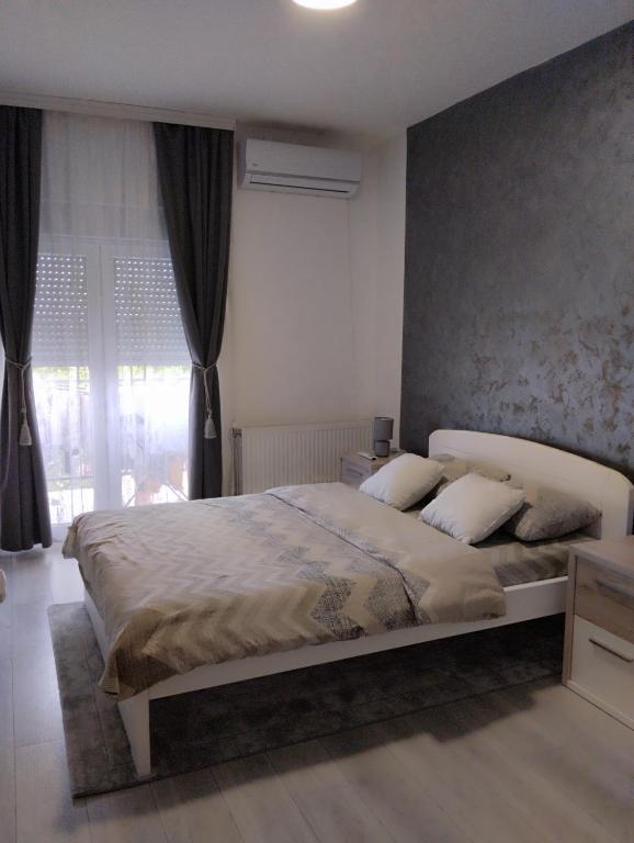 una camera da letto con un letto grande davanti a una finestra di Apartman Lenka a Sremska Mitrovica