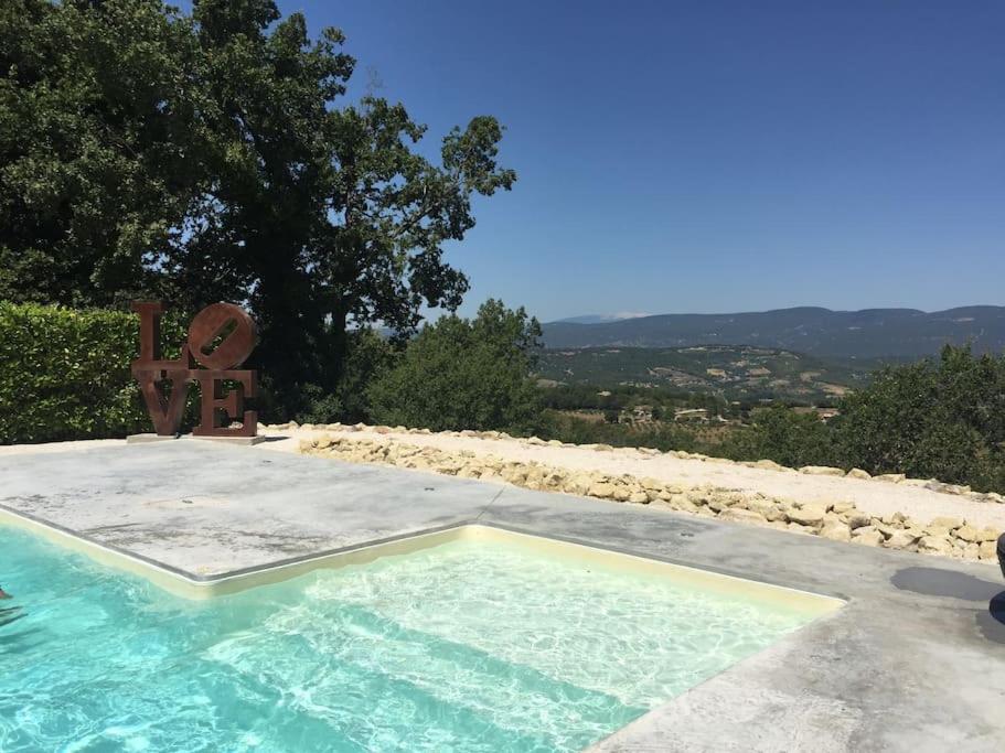 - une piscine avec une chaise à côté dans l'établissement Villa Saignon les plus beaux villages de France, à Saignon