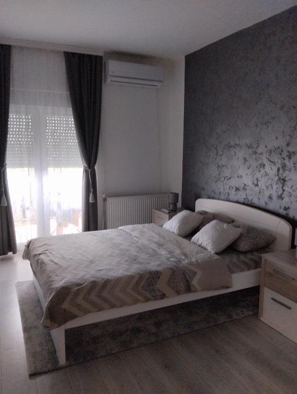 una camera da letto con un letto grande davanti a una finestra di Apartman Lenka a Sremska Mitrovica
