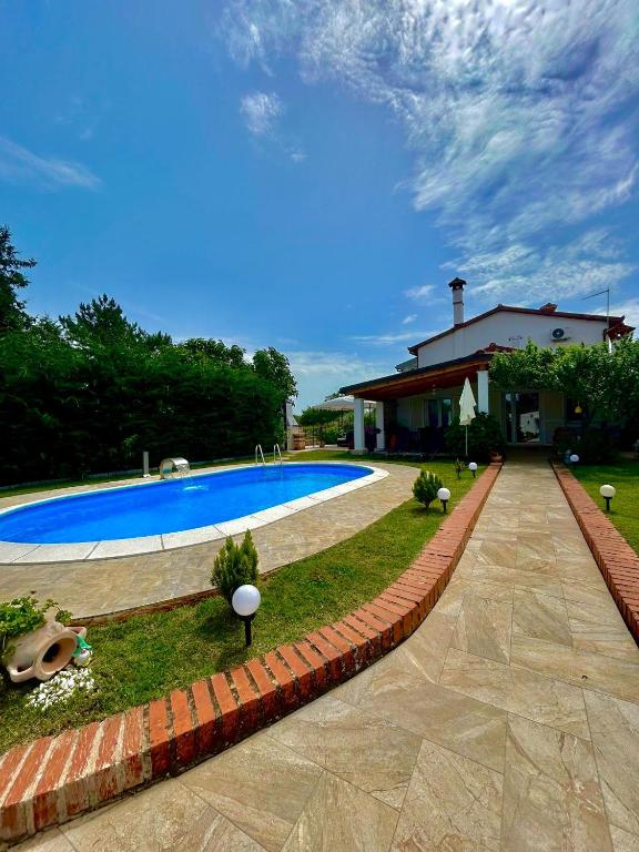 a swimming pool in a yard next to a house at Vila La Perla Istriana in Višnjan