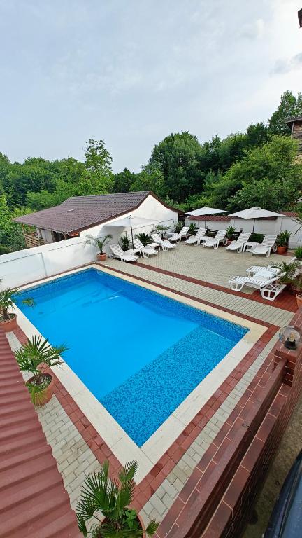 a large swimming pool with lounge chairs and a swimming pool at Vila Perla Govorei in Băile Govora