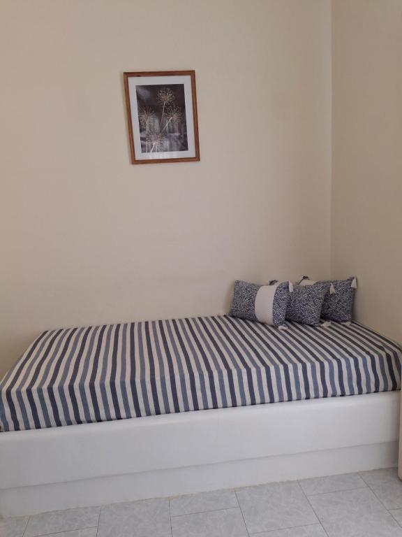 a bed sitting in a corner of a room at RESTIA in Agios Petros