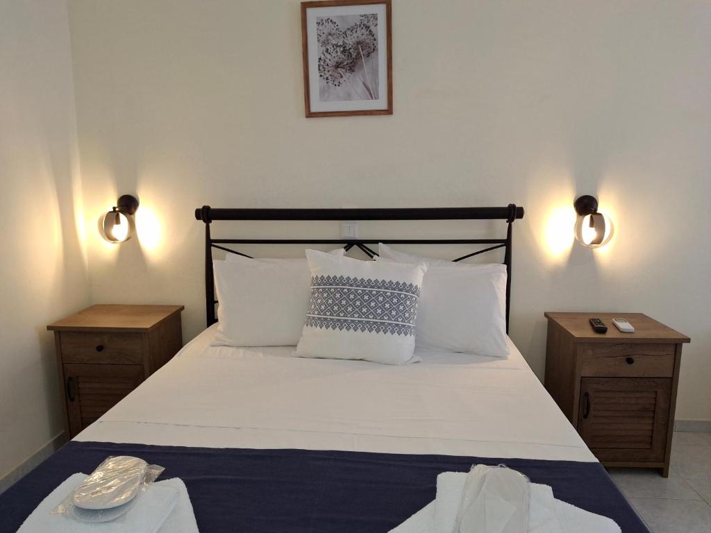 a bedroom with a bed with white sheets and pillows at RESTIA in Agios Petros