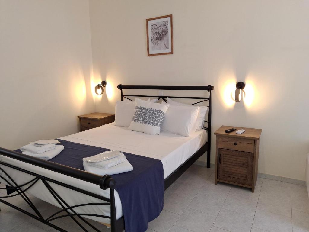a bedroom with a bed and two nightstands and a bed sidx sidx sidx at RESTIA in Agios Petros