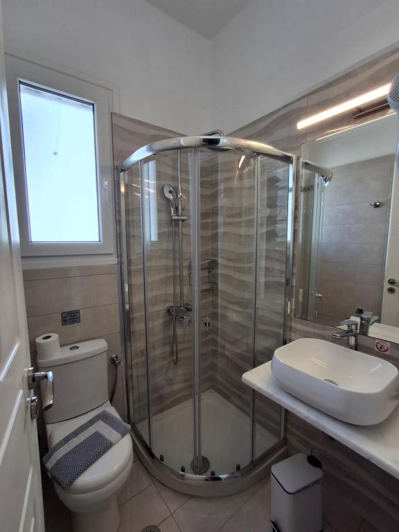 a bathroom with a shower and a toilet and a sink at RESTIA in Agios Petros