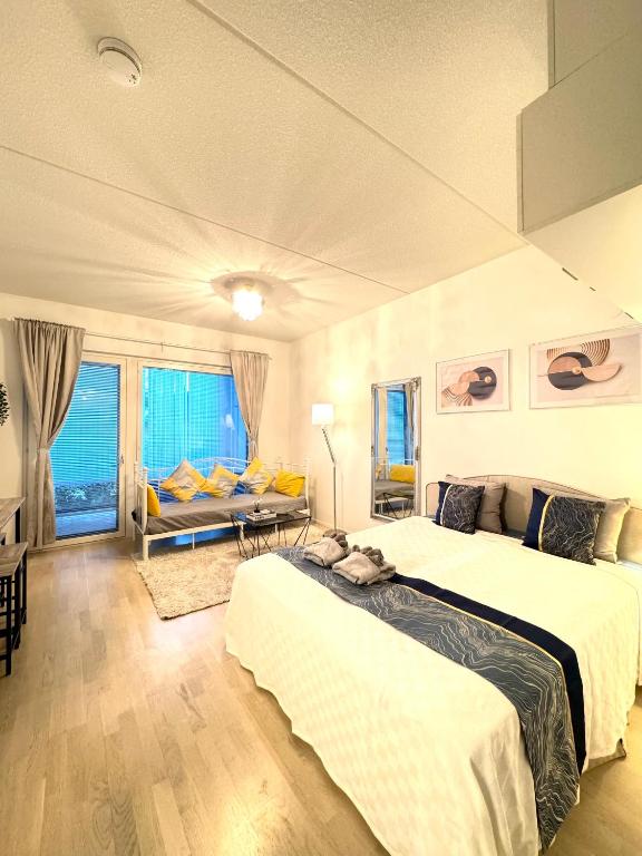 a hotel room with two beds and a couch at C&C Studio - Comfy Nest Near Airport & City Access in Vantaa