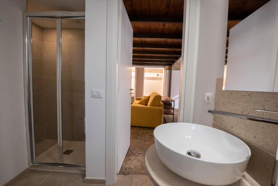 a bathroom with a white sink and a glass shower at Casa Alexina in Lesina