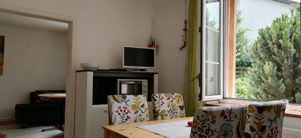 a living room with two chairs and a table and a television at Rita's FeWo in Grossschönau