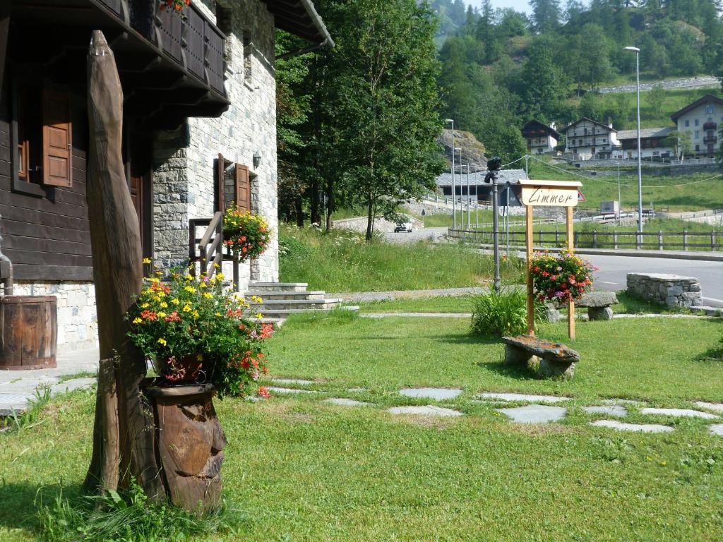 a house with flowers and a sign in the yard at Kleine in Gressoney-Saint-Jean